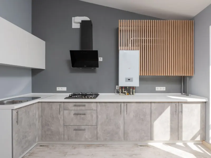 Dapur dengan kabinet motif beton, dinding abu tua, kabinet atas kisi kayu, dan tudung asap hitam